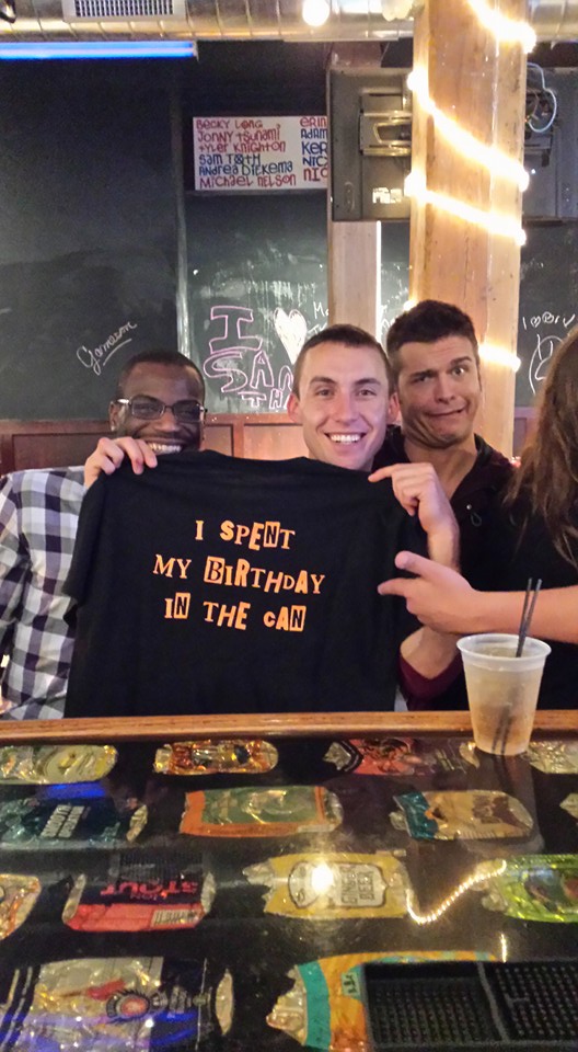 Customer holding an I Spent My Birthday in the Can t-shirt.